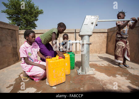 Le ragazze di ottenere acqua fresca da un pozzo in reparto Kouka, Burkina Faso, W. Africa. Foto Stock