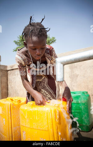 Le ragazze di ottenere acqua fresca da un pozzo in reparto Kouka, Burkina Faso, W. Africa. Foto Stock