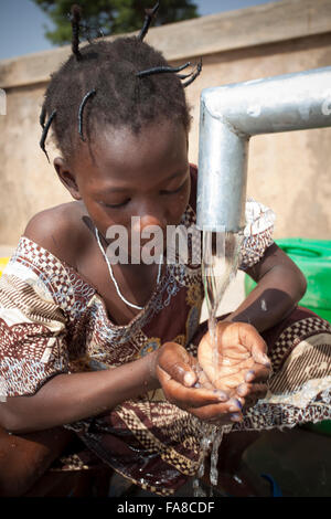 Le ragazze di ottenere acqua fresca da un pozzo in reparto Kouka, Burkina Faso, W. Africa. Foto Stock