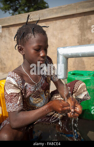 Le ragazze di ottenere acqua fresca da un pozzo in reparto Kouka, Burkina Faso, W. Africa. Foto Stock