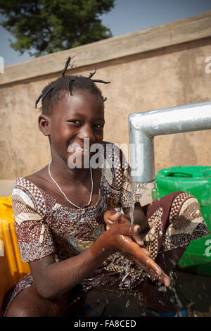 Le ragazze di ottenere acqua fresca da un pozzo in reparto Kouka, Burkina Faso, W. Africa. Foto Stock