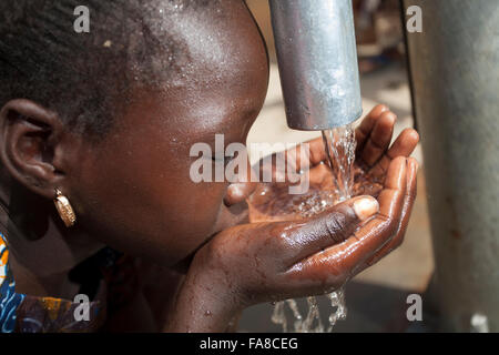 Le ragazze di ottenere acqua fresca da un pozzo in reparto Kouka, Burkina Faso, W. Africa. Foto Stock