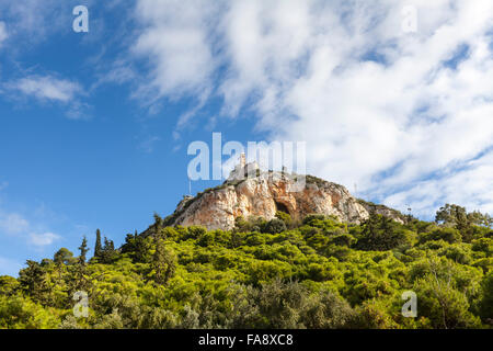 Il Monte Lycabettus, una collina calcarea con alberi di pino in corrispondenza della sua base e una popolare destinazione turistica in Atene, Grecia Foto Stock