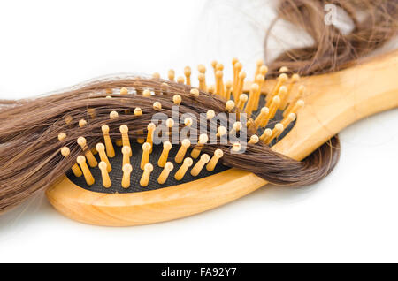 La perdita di capelli problema concetto. In legno spazzola per capelli e la caduta dei capelli su sfondo bianco. Foto Stock