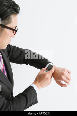 Imprenditore giapponese con smart indossabile watch Foto Stock
