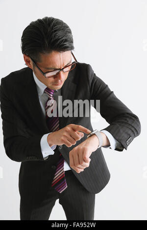 Imprenditore giapponese con smart indossabile watch Foto Stock