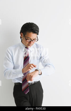 Imprenditore giapponese con smart indossabile watch Foto Stock