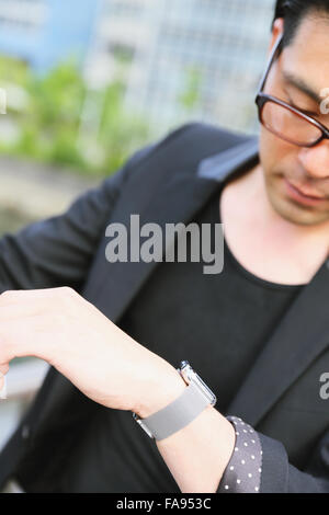 Imprenditore giapponese con smart indossabile watch Foto Stock