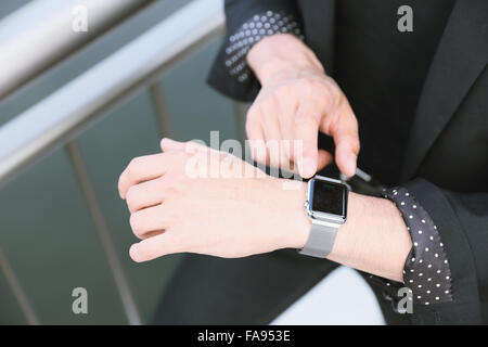 Imprenditore giapponese con smart indossabile watch Foto Stock