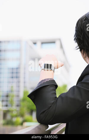 Imprenditore giapponese con smart indossabile watch Foto Stock