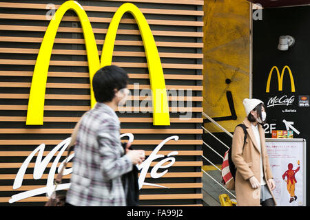 Tokyo, Giappone. 24 dicembre, 2015. I pedoni a piedi passato un poster che annuncia la chiusura del McDonald's più grande store in Giappone situato in Harajuku on gennaio 15, 2016. McDonald's secondo come riferito sta cercando di vendere il 15% al 33% di quote della sua filiale Giapponese e guadagno 100 miliardi di yen ($817 milioni di euro). McDonald's aziende Giappone è prevista una perdita netta di 38 miliardi di yen durante il suo anno fiscale conclusosi il 31 dicembre dopo gli scandali di scaduto il pollo nell'estate del 2014 e la contaminazione con corpi estranei nel gennaio 2015. © Rodrigo Reyes Marin/AFLO/Alamy Live News Foto Stock