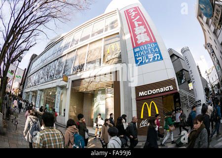 Tokyo, Giappone. 24 dicembre, 2015. I pedoni a piedi passato un poster che annuncia la chiusura del McDonald's più grande store in Giappone situato in Harajuku on gennaio 15, 2016. McDonald's secondo come riferito sta cercando di vendere il 15% al 33% di quote della sua filiale Giapponese e guadagno 100 miliardi di yen ($817 milioni di euro). McDonald's aziende Giappone è prevista una perdita netta di 38 miliardi di yen durante il suo anno fiscale conclusosi il 31 dicembre dopo gli scandali di scaduto il pollo nell'estate del 2014 e la contaminazione con corpi estranei nel gennaio 2015. © Rodrigo Reyes Marin/AFLO/Alamy Live News Foto Stock