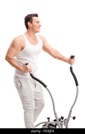 Colpo verticale di un giovane uomo che esercitano su un cross trainer e sorridente isolati su sfondo bianco Foto Stock