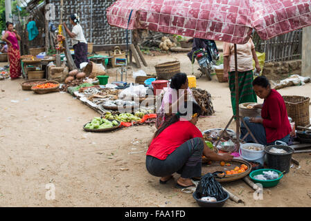 MYINKABA, Myanmar — i venditori locali espongono prodotti freschi e merci al mercato mattutino nel villaggio di Myinkaba, vicino a Bagan, Myanmar. Frutta colorata, verdura e cibi tradizionali si affiancano alle bancarelle improvvisate lungo la strada. Foto Stock