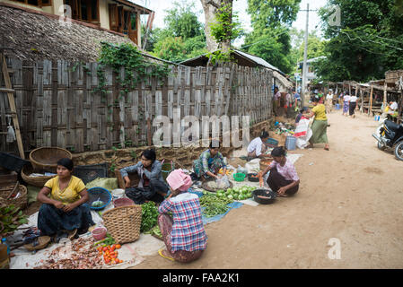 MYINKABA, Myanmar — i venditori locali espongono prodotti freschi e merci al mercato mattutino nel villaggio di Myinkaba, vicino a Bagan, Myanmar. Frutta colorata, verdura e cibi tradizionali si affiancano alle bancarelle improvvisate lungo la strada. Foto Stock