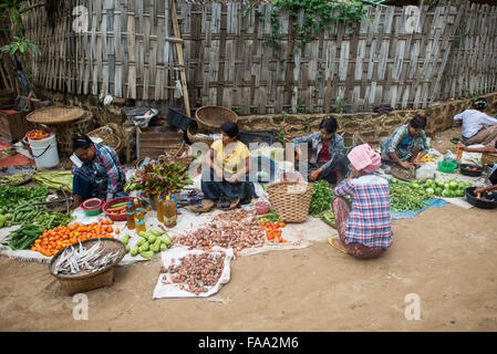 MYINKABA, Myanmar — i venditori locali espongono prodotti freschi e merci al mercato mattutino nel villaggio di Myinkaba, vicino a Bagan, Myanmar. Frutta colorata, verdura e cibi tradizionali si affiancano alle bancarelle improvvisate lungo la strada. Foto Stock