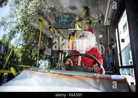 Buenos Aires, Argentina. 24 dicembre, 2015. Cristian Gabriel Tamasi, conducente di autobus di linea 39, rende la sua rotta abituale vestito come Babbo Natale, nella città di Buenos Aires, capitale dell'Argentina, per il 24 dicembre, 2015. Cristian, 22-anno-vecchio, è stato un conducente di bus per un anno e mezzo. Egli ha deciso di andare al lavoro vestiti da Babbo Natale per dare gioia ai passeggeri e a diffondere lo spirito del Natale. © Martin Zabala/Xinhua/Alamy Live News Foto Stock