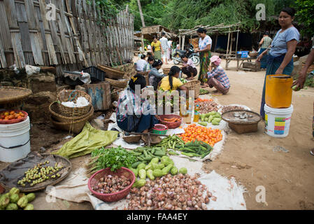 MYINKABA, Myanmar — i venditori locali espongono prodotti freschi e merci al mercato mattutino nel villaggio di Myinkaba, vicino a Bagan, Myanmar. Frutta colorata, verdura e cibi tradizionali si affiancano alle bancarelle improvvisate lungo la strada. Foto Stock