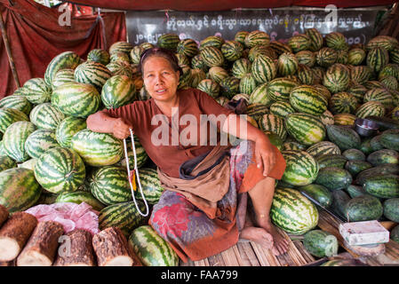 MYINKABA, Myanmar — i venditori locali espongono prodotti freschi e merci al mercato mattutino nel villaggio di Myinkaba, vicino a Bagan, Myanmar. Frutta colorata, verdura e cibi tradizionali si affiancano alle bancarelle improvvisate lungo la strada. Foto Stock