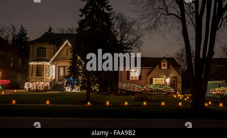 Chicago, Stati Uniti d'America. Il 24 dicembre 2015. La parte anteriore dei giardini delle case nel villaggio di Clarendon Hills sono decorate con 'luminaria', candele accese in borse di carta marroni. Festeggia il suo cinquantesimo anniversario, la tradizione annuale richiede ai residenti locali di luce delle candele ogni vigilia di Natale e solleva i soldi per bambini locali di beneficenza, con più di 30.000 candele essendo accesa. Credito: Stephen Chung / Alamy Live News Foto Stock