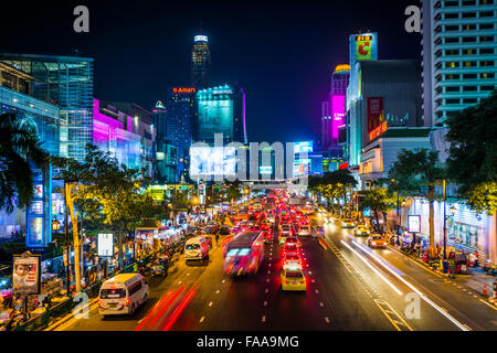 Una lunga esposizione di traffico e di moderni edifici su Ratchadamri Road di notte, al Siam, a Bangkok, in Thailandia. Foto Stock