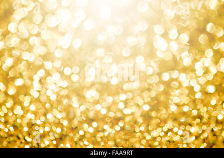 Oro festa delle luci di sfondo. Abstract sfondo luminoso con bokeh sfocato luci d'oro Foto Stock