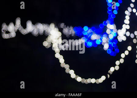 Le luci di Natale sfocata nel buio Foto Stock