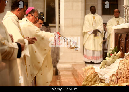 Betlemme, Chiesa della Natività. 25 Dic, 2015. Il Patriarca Latino di Gerusalemme Fouad Twal (3 L) conduce una Messa di Mezzanotte di Natale, alla Chiesa della Natività, in Cisgiordania città di Betlemme a Dic. 25, 2015. Credito: Piscina/Fadi Arouri/Xinhua/Alamy Live News Foto Stock