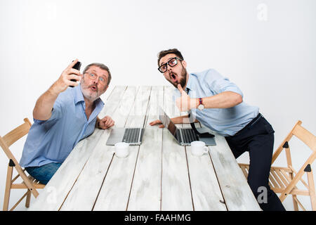 Due colleghi facendo le foto alla loro auto seduto in ufficio Foto Stock