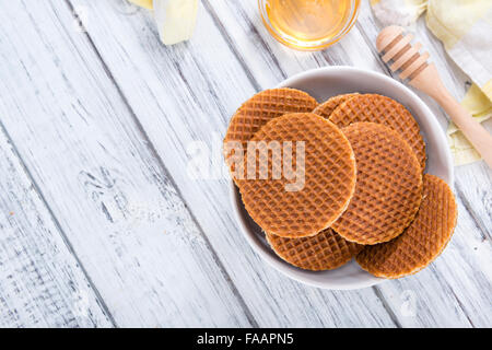 Cialde croccanti riempito con miele su sfondo di legno Foto Stock