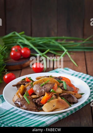 Arrosto di fegato di pollo con verdure su sfondo di legno Foto Stock