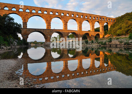 Acquedotto Romano di Pont du Gard riflessa nel fiume Gardon in serata, Remoulins, Provenza, Francia meridionale, Francia, Europa Foto Stock