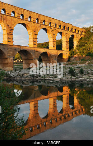 Acquedotto Romano di Pont du Gard riflessa nel fiume Gardon in serata, Remoulins, Provenza, Francia meridionale, Francia, Europa Foto Stock