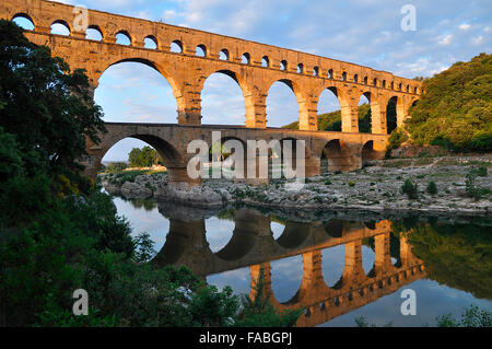 Acquedotto Romano di Pont du Gard riflessa nel fiume Gardon in serata, Remoulins, Provenza, Francia meridionale, Francia, Europa Foto Stock