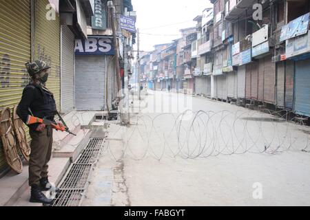 La questione del Kashmir, India. 26 dicembre, 2015. Un poliziotto indiano si erge nei pressi di filo spinato durante il coprifuoco a Maisuma. © Basit Zargar/Live News Foto Stock