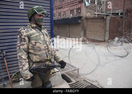 La questione del Kashmir, India. 26 dicembre, 2015. Un poliziotto indiano si erge nei pressi di filo spinato durante il coprifuoco a Maisuma. Credito: Basit Zargar/ Alamy Live News Foto Stock