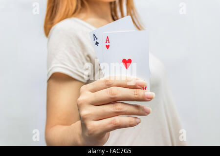 Giovane donna tenendo in mano la scheda di poker con combinazione di Full House. in mano di messa a fuoco e poker card. Foto Stock