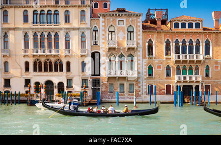 I turisti in gondola veneziana in Grand Canal, edifici storici in background, Venezia, Italia