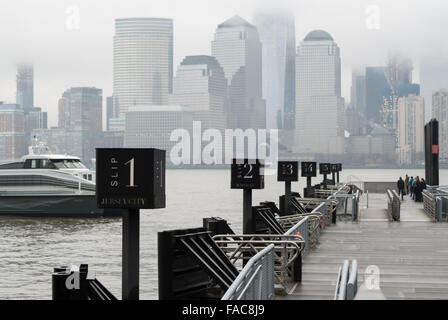 Persone in attesa per il prossimo traghetto per dock presso il Paulus il gancio terminale dei traghetti su una grigia giornata di nebbia in Jersey City Foto Stock