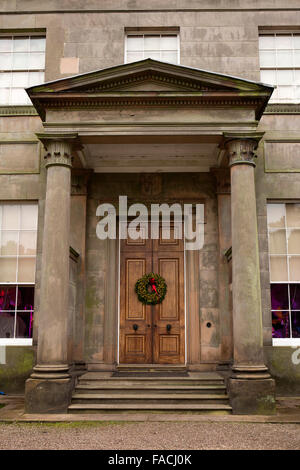 Regno Unito, Inghilterra, Cheshire, Knutsford, Tatton Hall, tradizionale Natale holly corona sulla porta principale in portiico Foto Stock