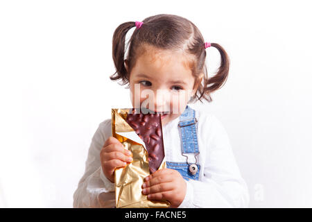 Ritratto di felice ragazza mangiando cioccolato. Isolato su sfondo bianco Foto Stock