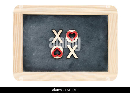 Telaio in legno vintage chalkboard isolato su bianco con testo XOXO (Baci & Abbracci) creato in legno lettere, lettere o coperto con cuore rosso forma simboli, il concetto di amore Foto Stock