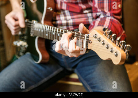 Vista ravvicinata delle mani dell'uomo suonare la chitarra elettrica. Foto Stock