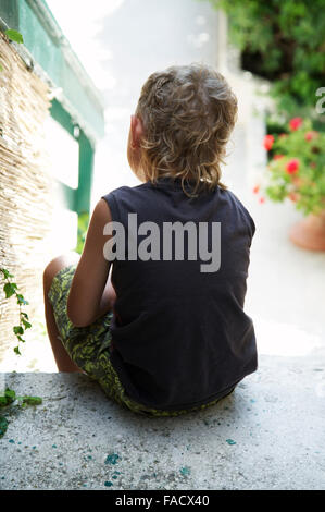 Stanco ragazzo seduto sulle scale Foto Stock