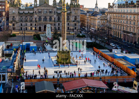 Glasgow, Regno Unito. 27 Dic, 2015. Il primo giorno di sole dopo Natale, alcuni dei cacciatori di affare presso il nuovo anno le vendite, prendetevi del tempo per godere di 'Glasgow su ghiaccio', un open air rink di George Square che sarà lì fino al nuovo anno. Credito: Findlay/Alamy Live News Foto Stock