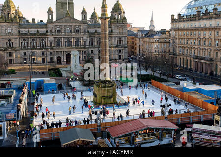 Glasgow, Regno Unito. 27 Dic, 2015. Il primo giorno di sole dopo Natale, alcuni dei cacciatori di affare presso il nuovo anno le vendite, prendetevi del tempo per godere di 'Glasgow su ghiaccio', un open air rink di George Square che sarà lì fino al nuovo anno. Credito: Findlay/Alamy Live News Foto Stock