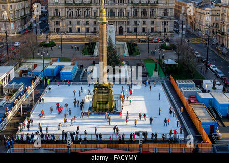 Glasgow, Regno Unito. 27 Dic, 2015. Il primo giorno di sole dopo Natale, alcuni dei cacciatori di affare presso il nuovo anno le vendite, prendetevi del tempo per godere di 'Glasgow su ghiaccio', un open air rink di George Square che sarà lì fino al nuovo anno. Credito: Findlay/Alamy Live News Foto Stock