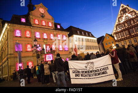 Un yound l uomo e la donna in attesa di un banner che recita "Gegen Fremdenfeindlichkeit und Rechtsextremismus' (lt. Contro la xenofobia e l' estremismo di destra) di fronte al Municipio dove centinaia di residenti si sono riuniti per ascoltare Richard Arnold (CDU), Sindaco di Schwabisch Gmuend leggere la spiegazione Gmennder per la tolleranza e apertura al mercato posto nella parte anteriore del Schwaebian Hall di Schwabisch Gmuend, Germania, 27 dicembre 2015. Dopo un attacco incendiario contro la costruzione di un rifugiato ostello a Schwabisch Gmuend, tutte le parti della Gmuender consiglio hanno condannato l'atto e hanno firmato un "Gmuend Foto Stock