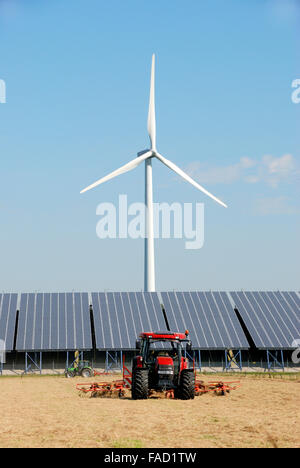 Impianto solare con turbina eolica presso un'azienda agricola nei Paesi Bassi.Di fronte due trattori Foto Stock