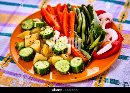 Siviera di vapore fresco raccolte verdure giovani compresi crinkle tagliare le carote affettate, piselli e manganelli di patate Foto Stock